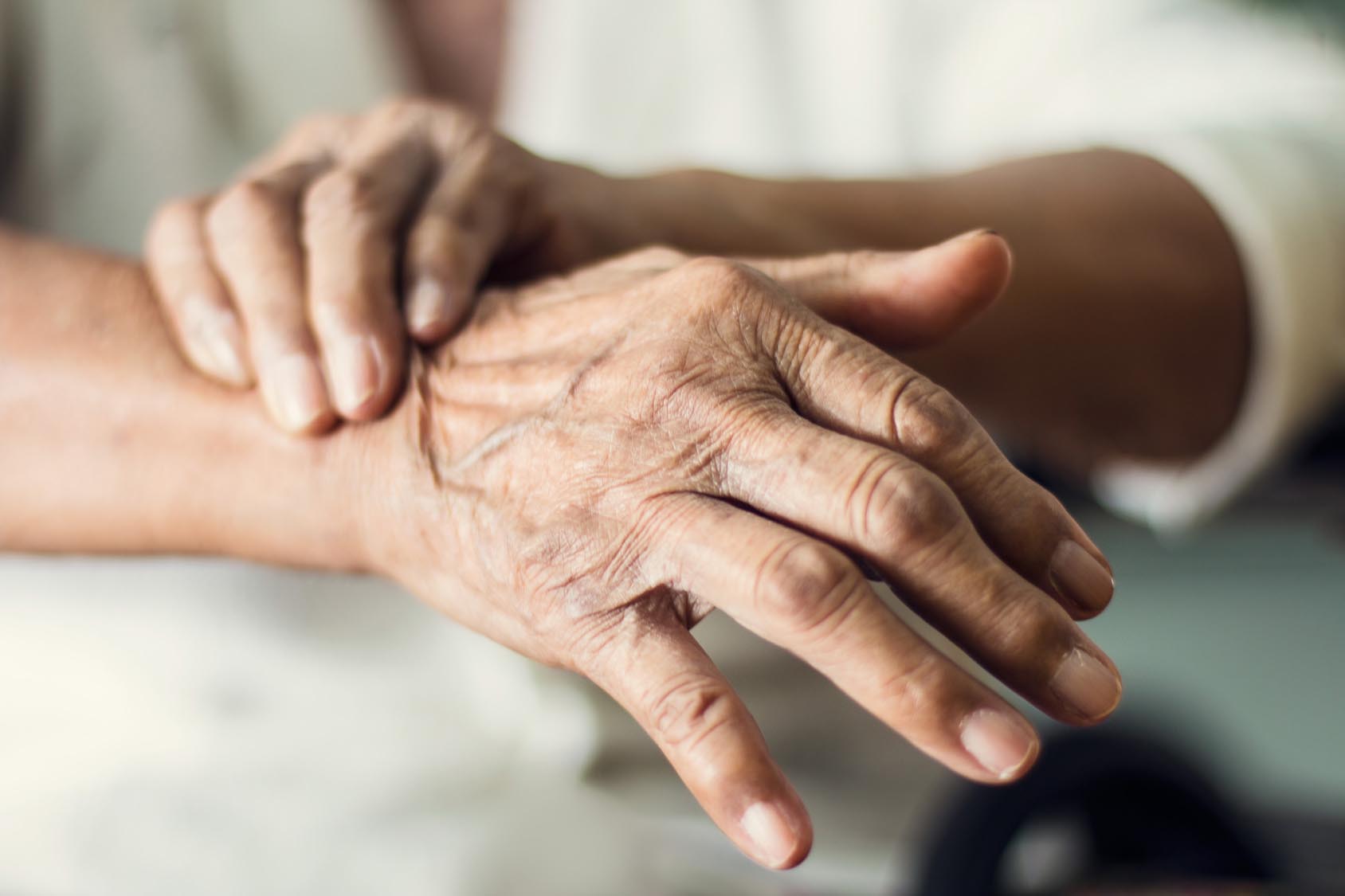 Close up hands of senior elderly woman patient suffering from pa